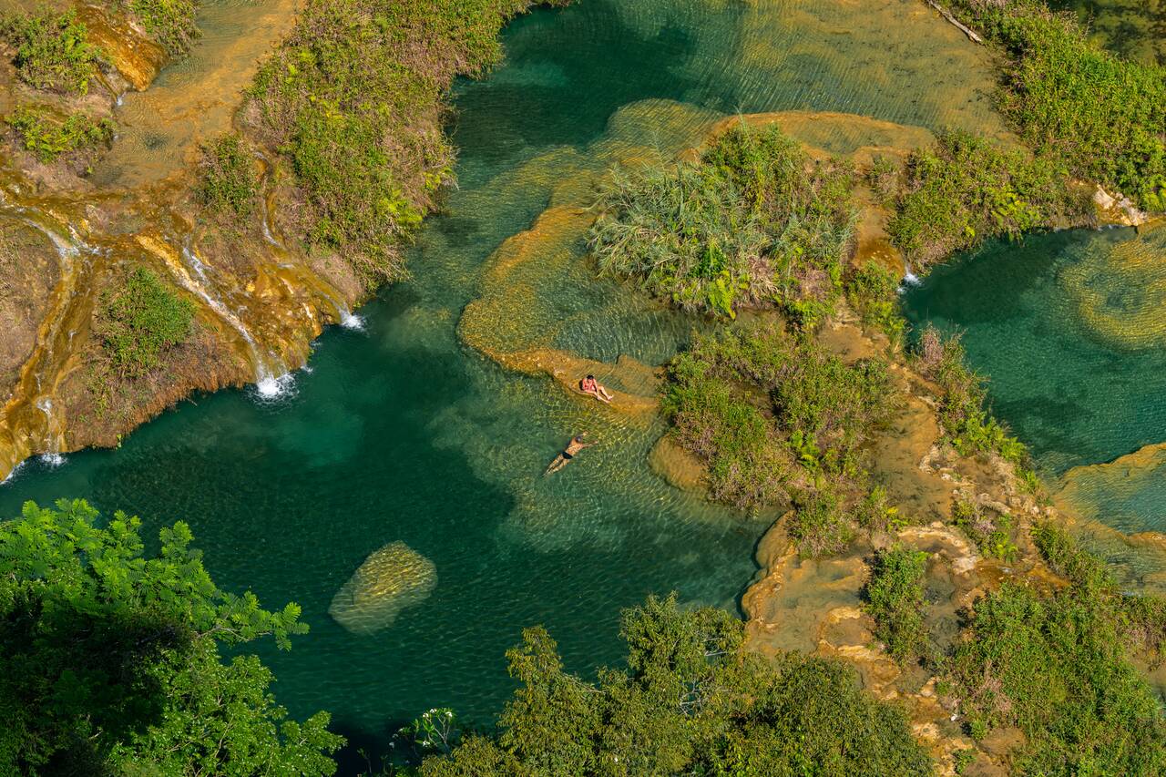 2 people hanging out at a quieter part of Semuc Champey seen from above