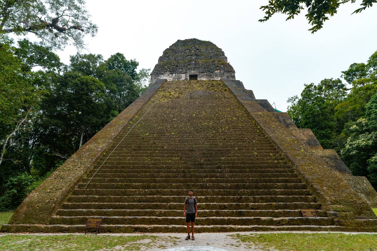 Me standing in front of a massive pyramid in Tikal