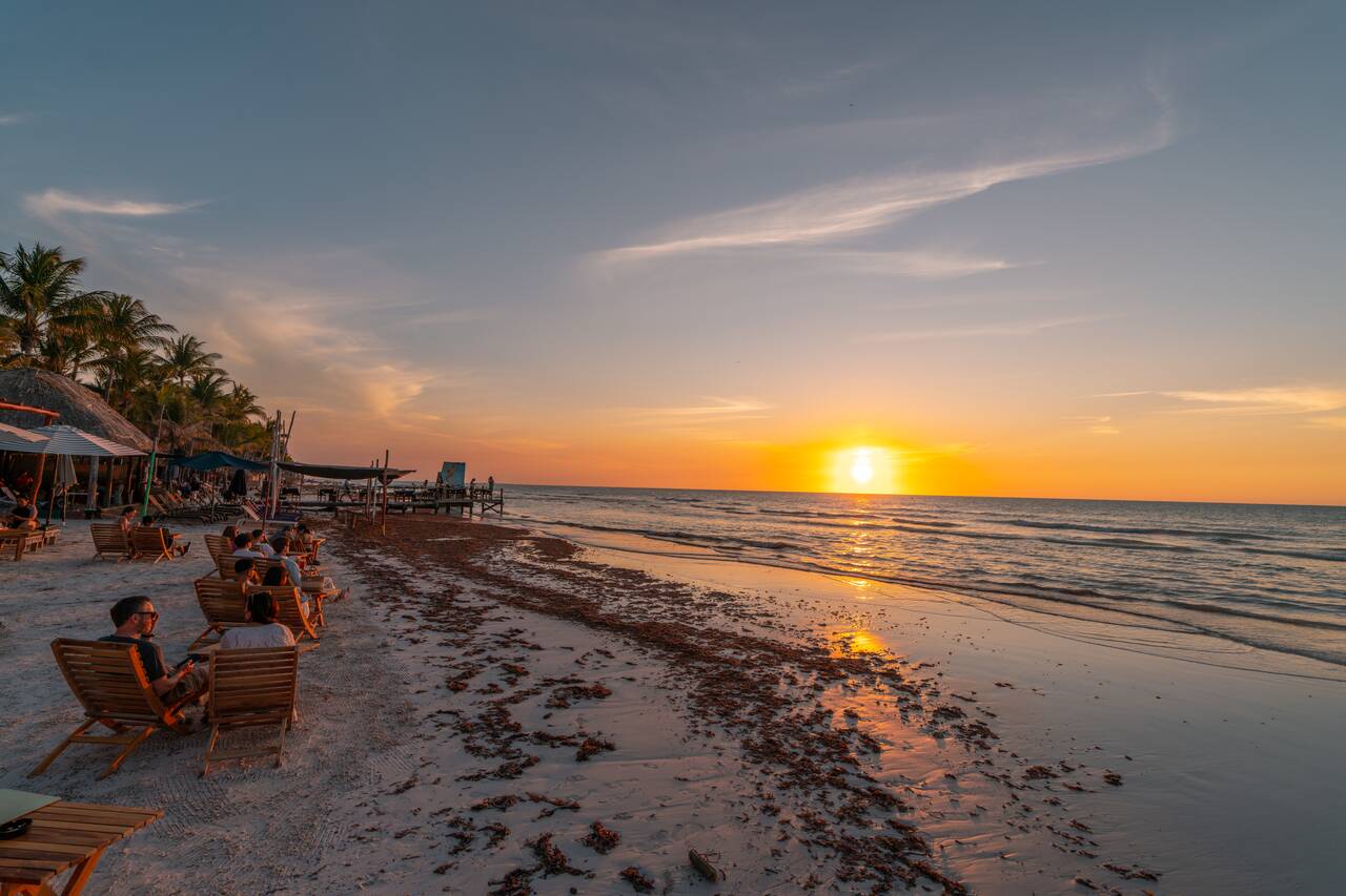 People sitting at a bar watching the sunset at Playa Holbox