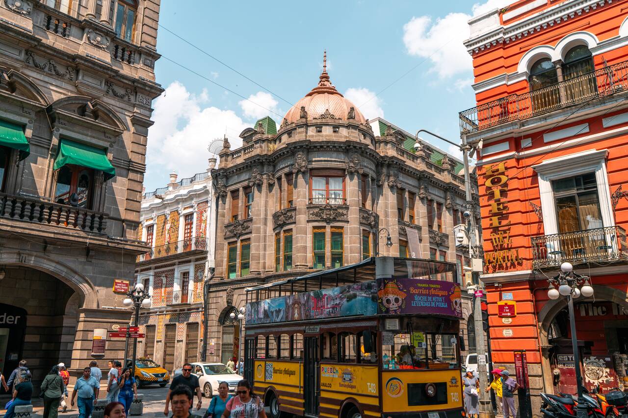 A double decker bus passing through the street of Puebla