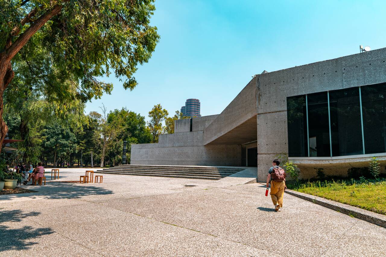 A person walking pass a museum on a nice day in Mexico City