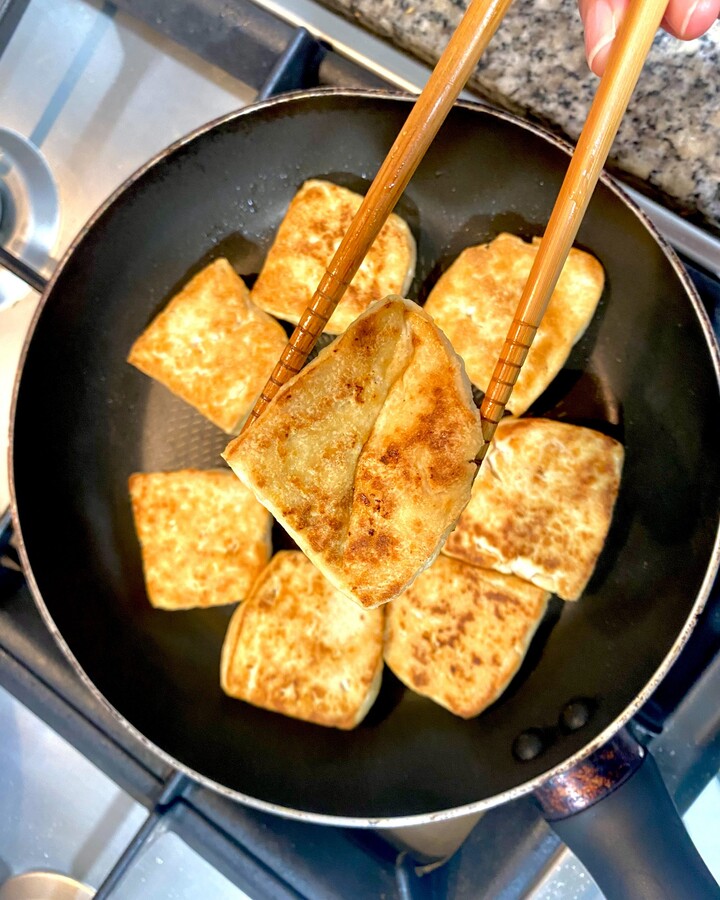 Heat a pan-fry over medium-high heat. Add the tofu and toss to crisp up on all sides until it is cooked and crisped on all sides.