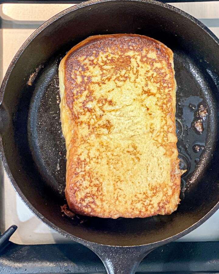 Place a slice of soaked bread on the skillet pan. Fry the french toast until browned on both sides.