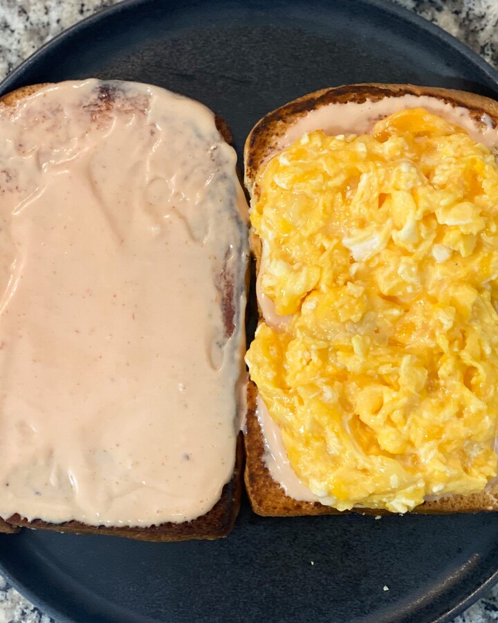 Spread mix Sriracha hot sauce on grilled toast. And add Scramble egg, and protein. Top with mixed sriracha sauce.