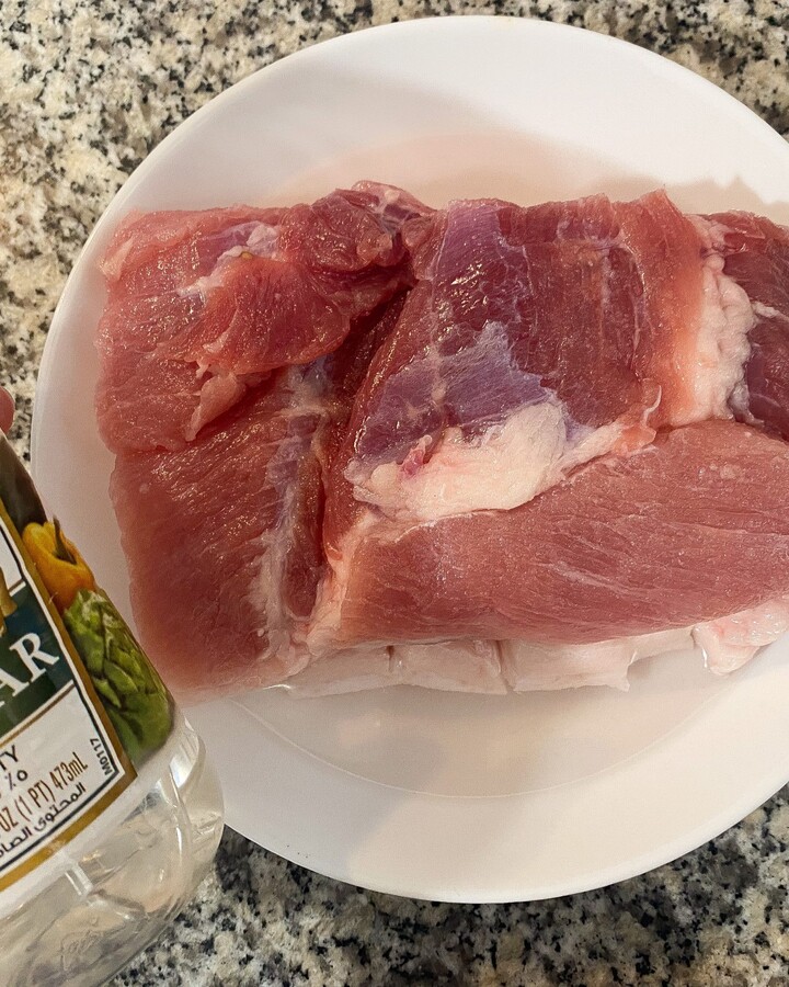 Place a pork belly into a bowl and you have to turn the skin of the pork side down. And then pour the vinegar just over the skin and leave it for 20 minutes.