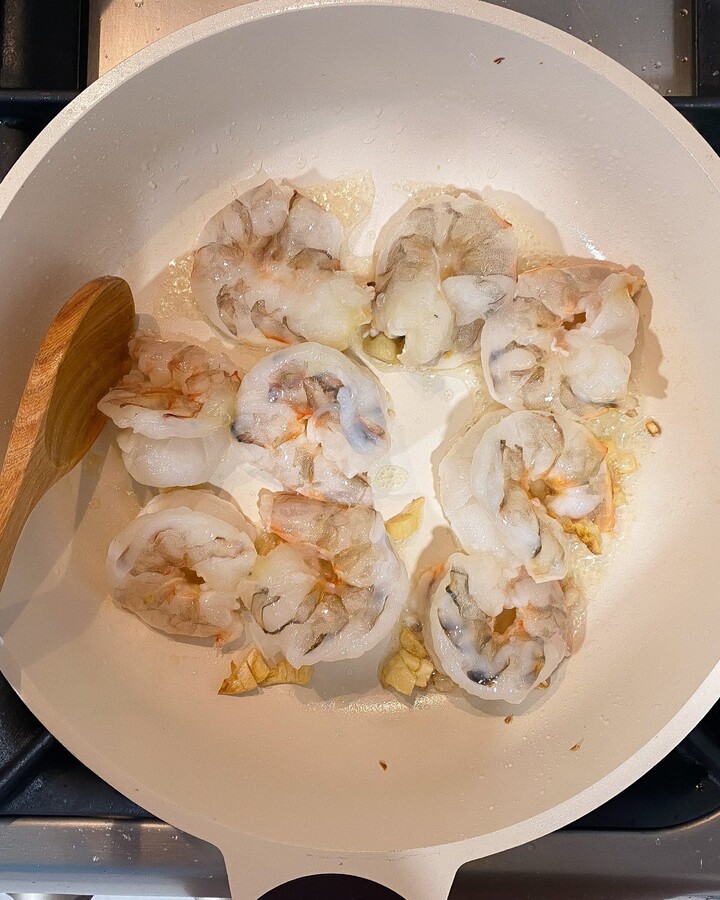 Heat a skillet over high, add some cooking oil and garlic clove and stir until it goes yellow and aromatic. Add shrimp and cook over high heat for about 2-3 minutes and then flip the shrimp wait for them to get cook but do not overcook.