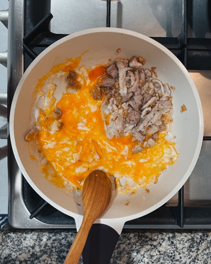 Add some eggs and stir frequently until they are scrambled and lightly cooked.