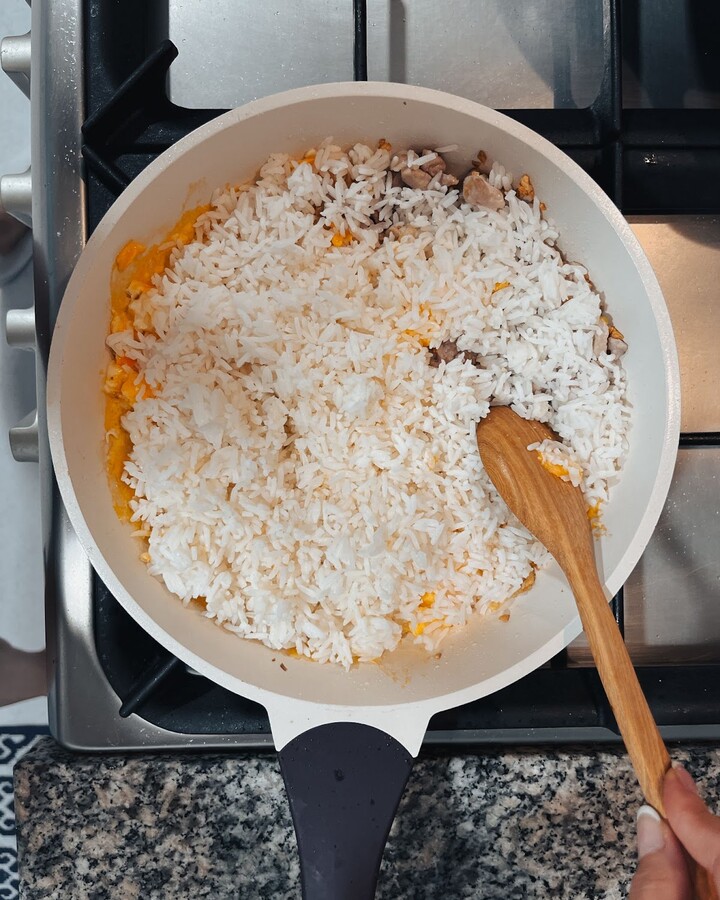 Add some chilled leftover rice and continue to stir.