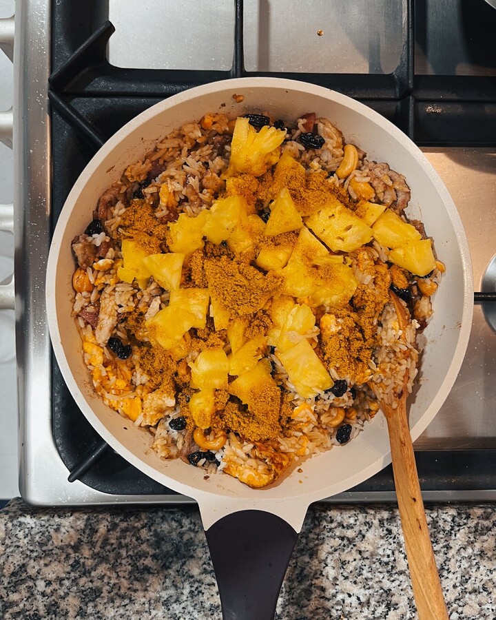Pour in pieces of the pineapple and curry powder, and continue to cook for an additional 3-5 minutes until the mixture is fragrant and dry.