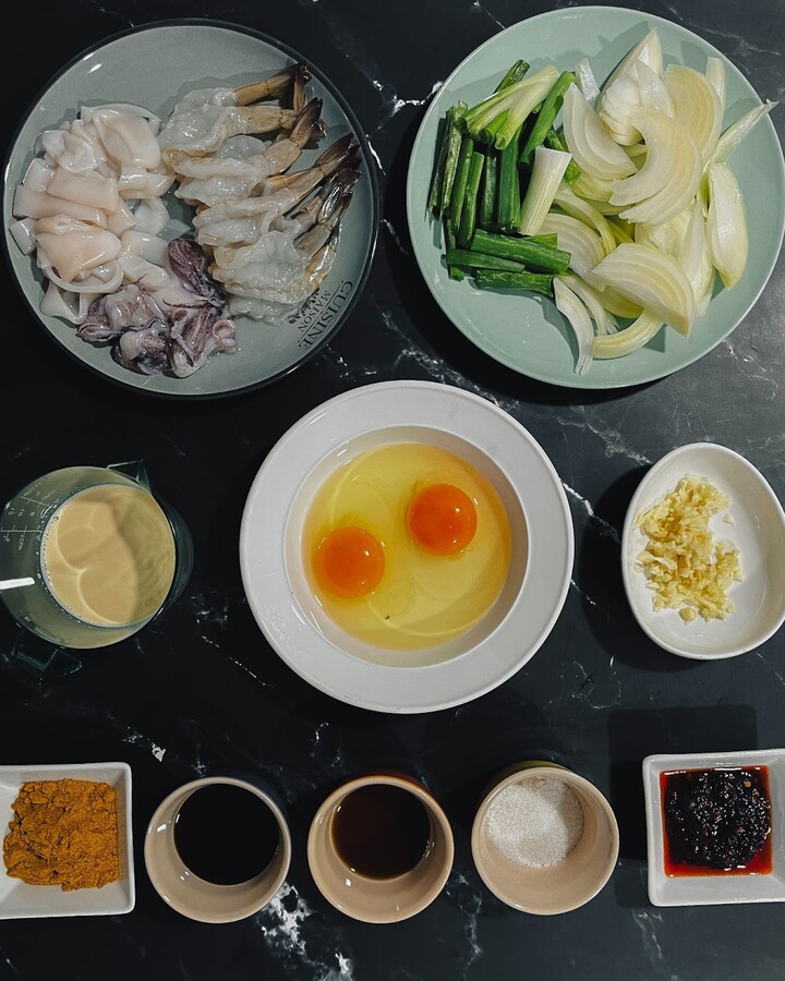To prepare the shrimps and squids for this recipe, remove the head, shell, and antennae from the shrimps, devein and rinse them thoroughly, and remove the head and innards from the squids, cut the squids into rings.