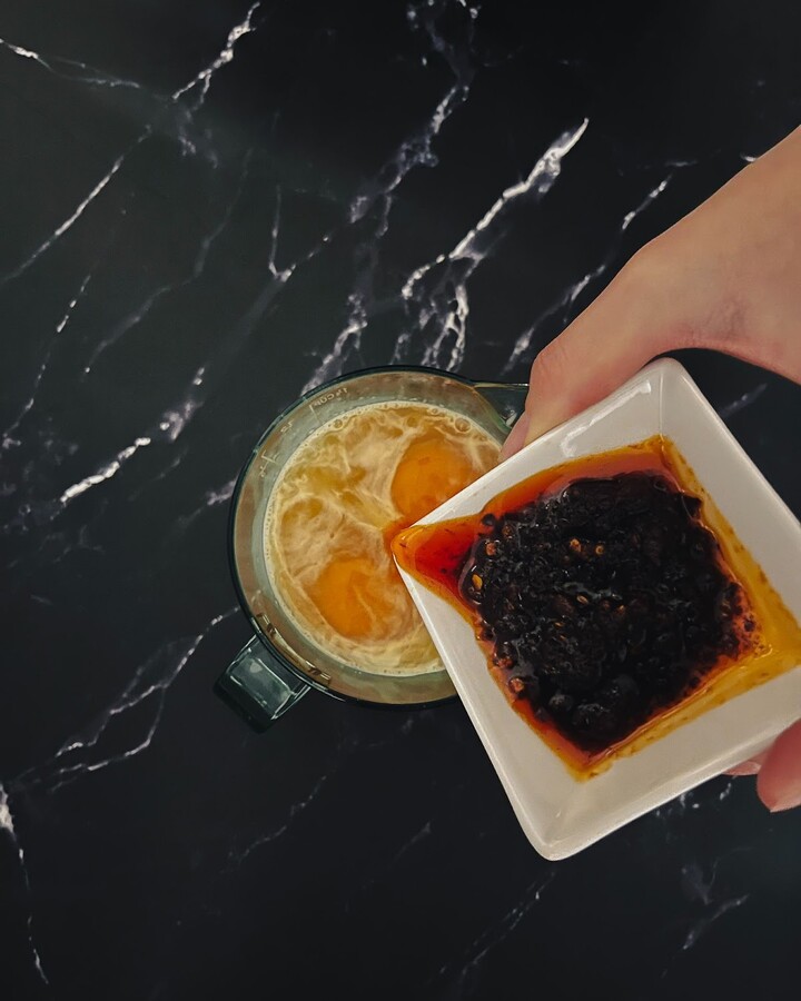 To prepare the mix sauce for this recipe, combine 2 eggs with Thai roasted chili paste, oyster sauce, soy sauce, sugar, and yellow curry in a bowl.