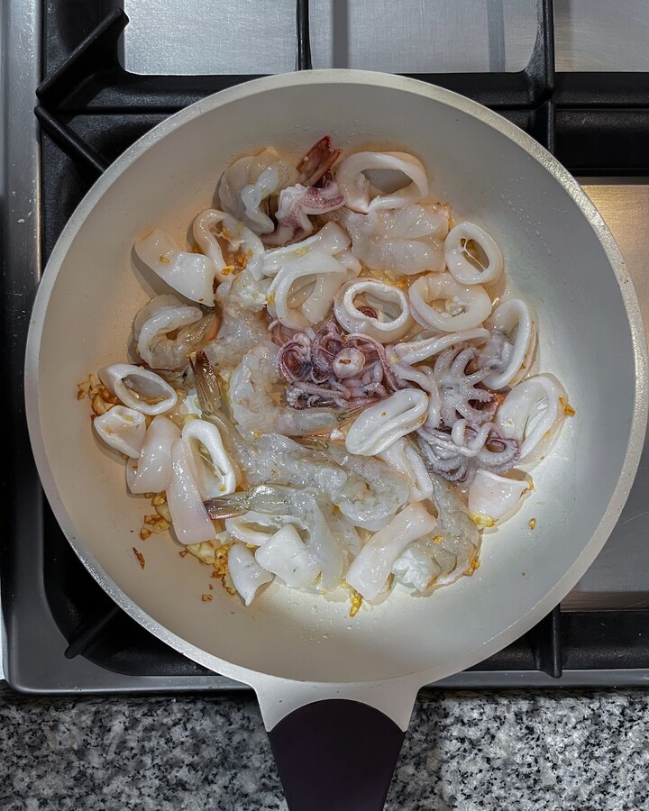Add shrimps and squid rings to the pan and continue stirring until they are cooked, approximately 5 minutes.