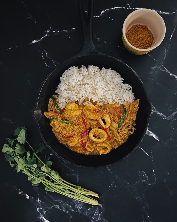 Lower the heat and serve the dish over steamed rice, optionally garnishing with red chili for decoration.