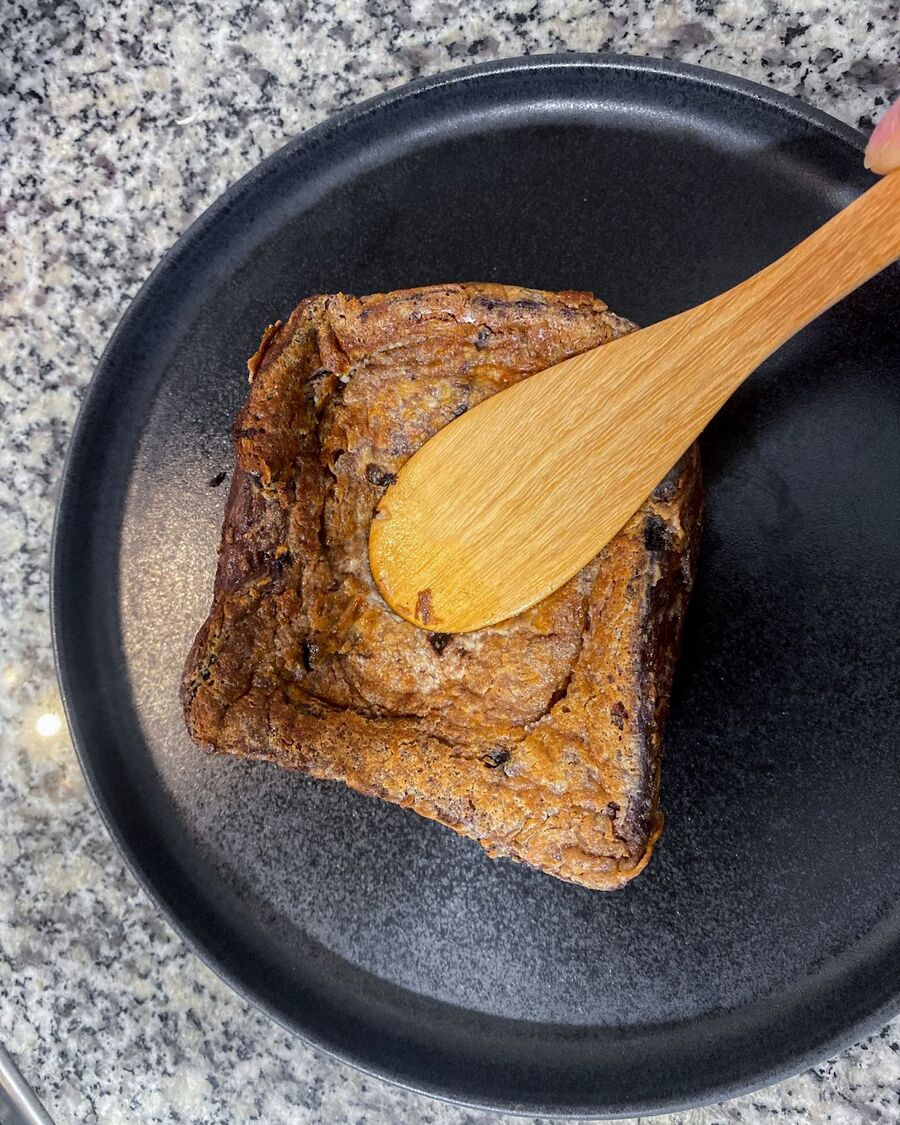 Press down on the center of the bread with a spoon or spatula to create a hold in the bread.