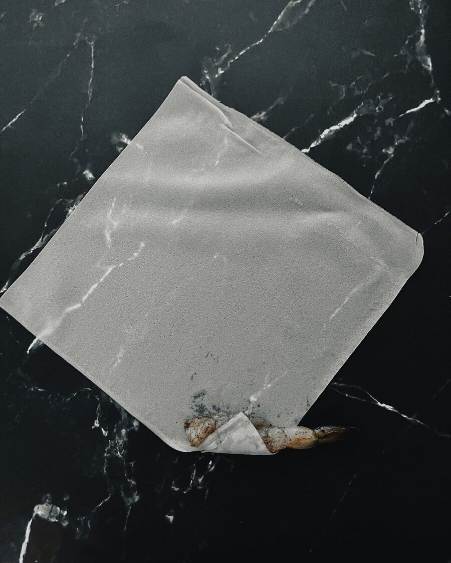 Place the spring roll wrapper on a flat surface with one of the corners facing towards you. Place the shrimp in the middle of the corner, keeping the tail outside of the wrapper.