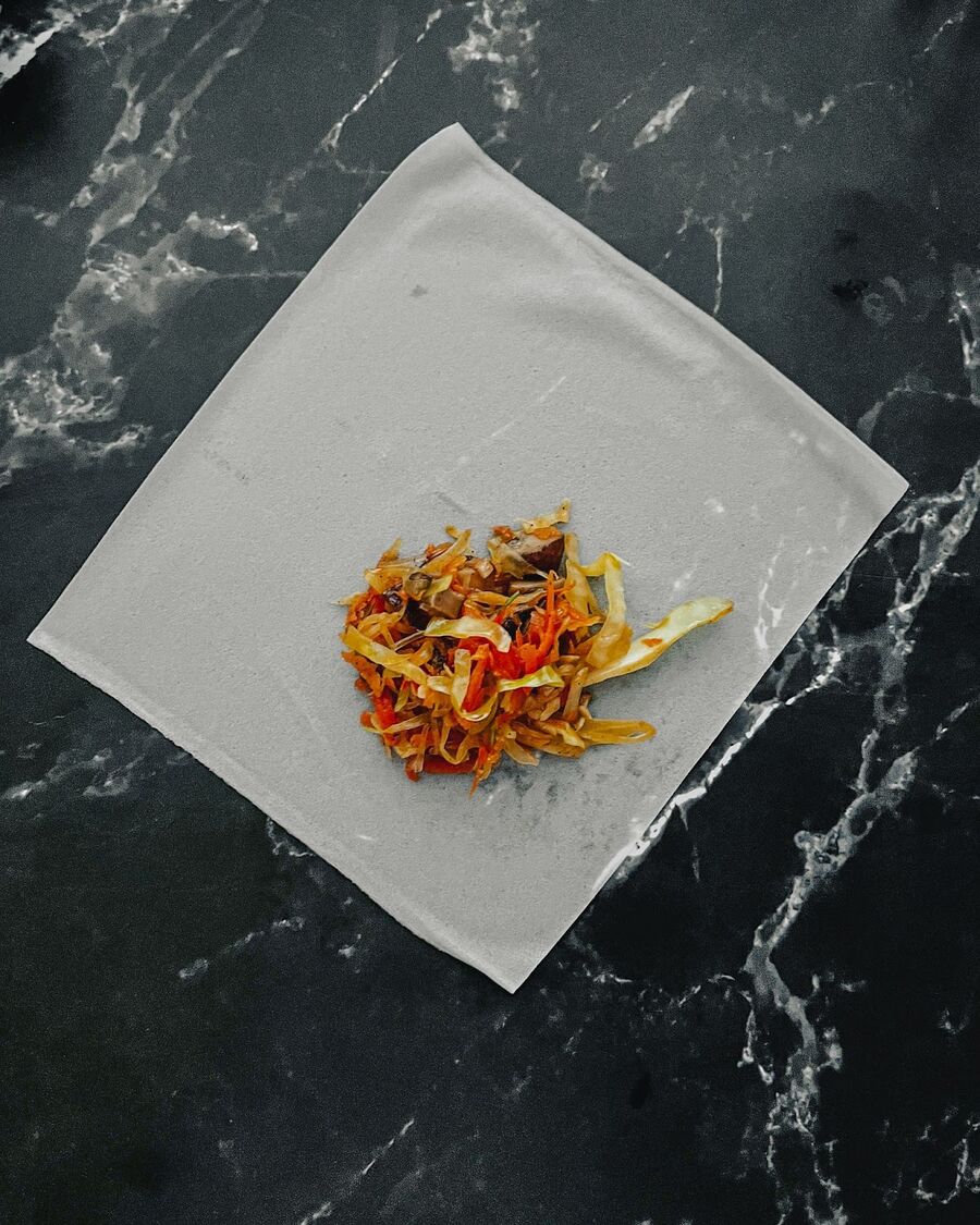 When the filling is ready and no longer hot, place a spring roll wrapper on a flat surface with one of the corners facing towards you. Place the filling in the middle of that corner.