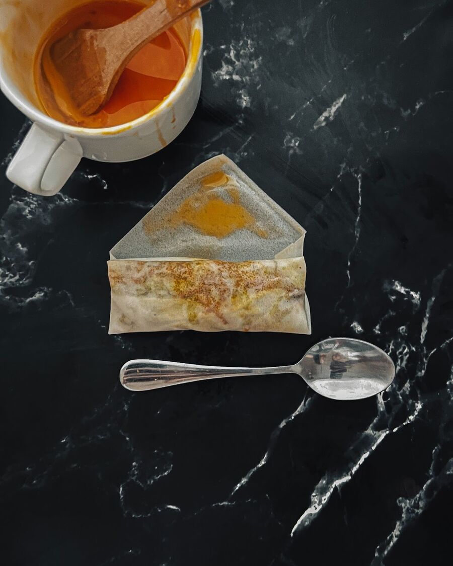 Continue rolling the spring roll up to the top and seal it with a brush of egg wash.