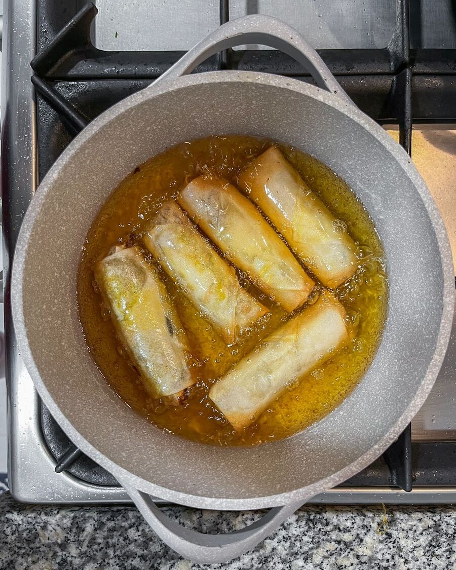 Heat a pot or pan with cooking oil to a depth of about 4 inches over high heat. When the oil is hot, carefully place the spring rolls into the pot.