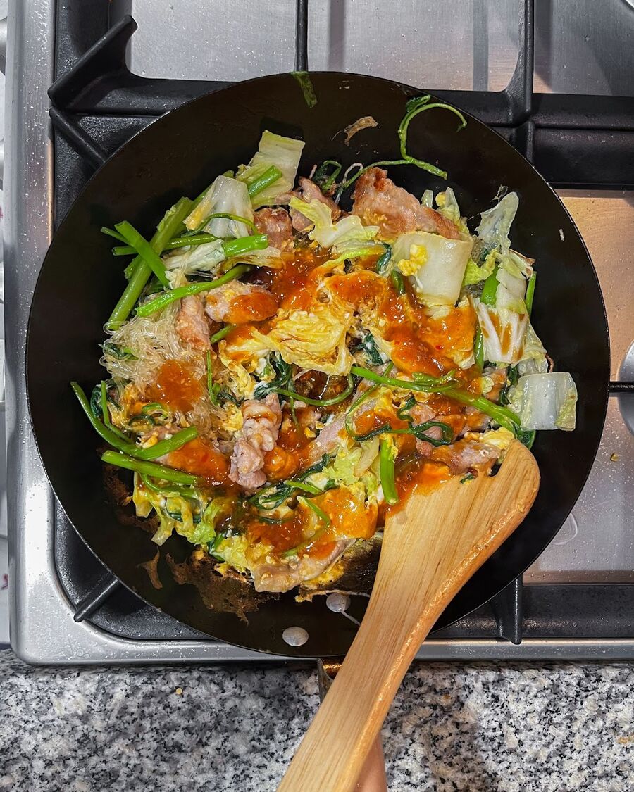 Pour all of the sauces over the ingredients in the wok.