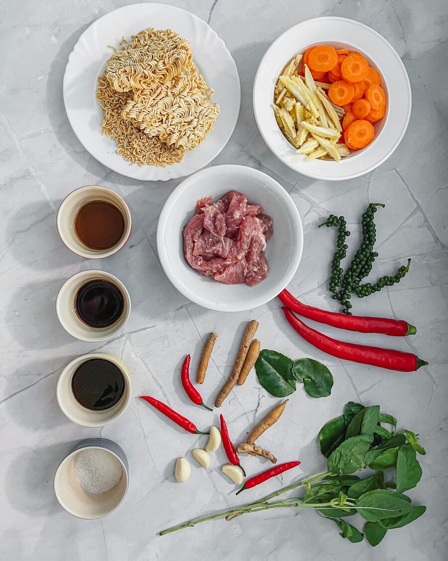 Gather all the necessary ingredients. Chop the carrots and baby corn into small, bite-sized pieces. Slice the large chili and finger root, and mince the garlic and small chili.
