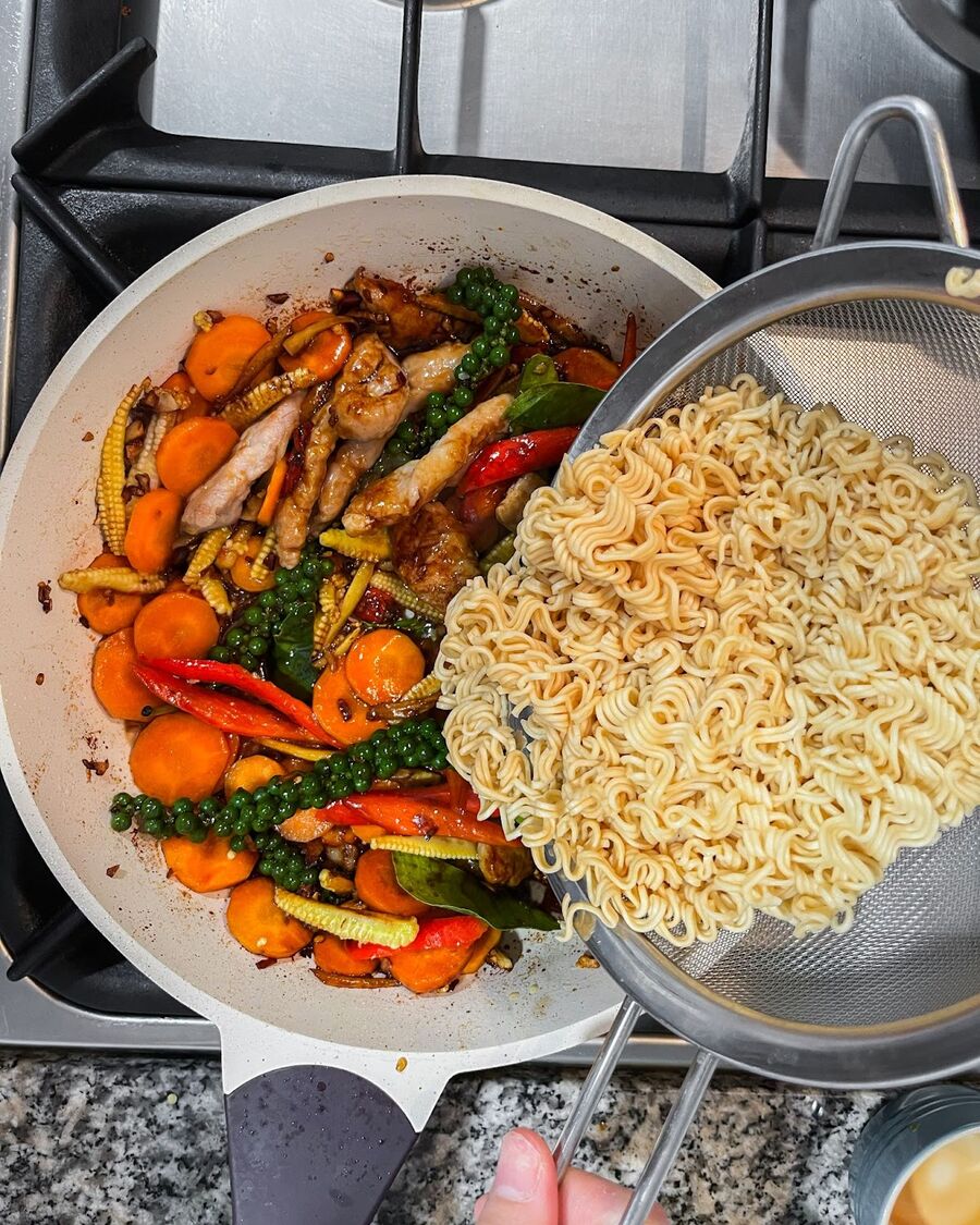 Add the noodles to the pan and continue stirring until they are coated with the sauce.