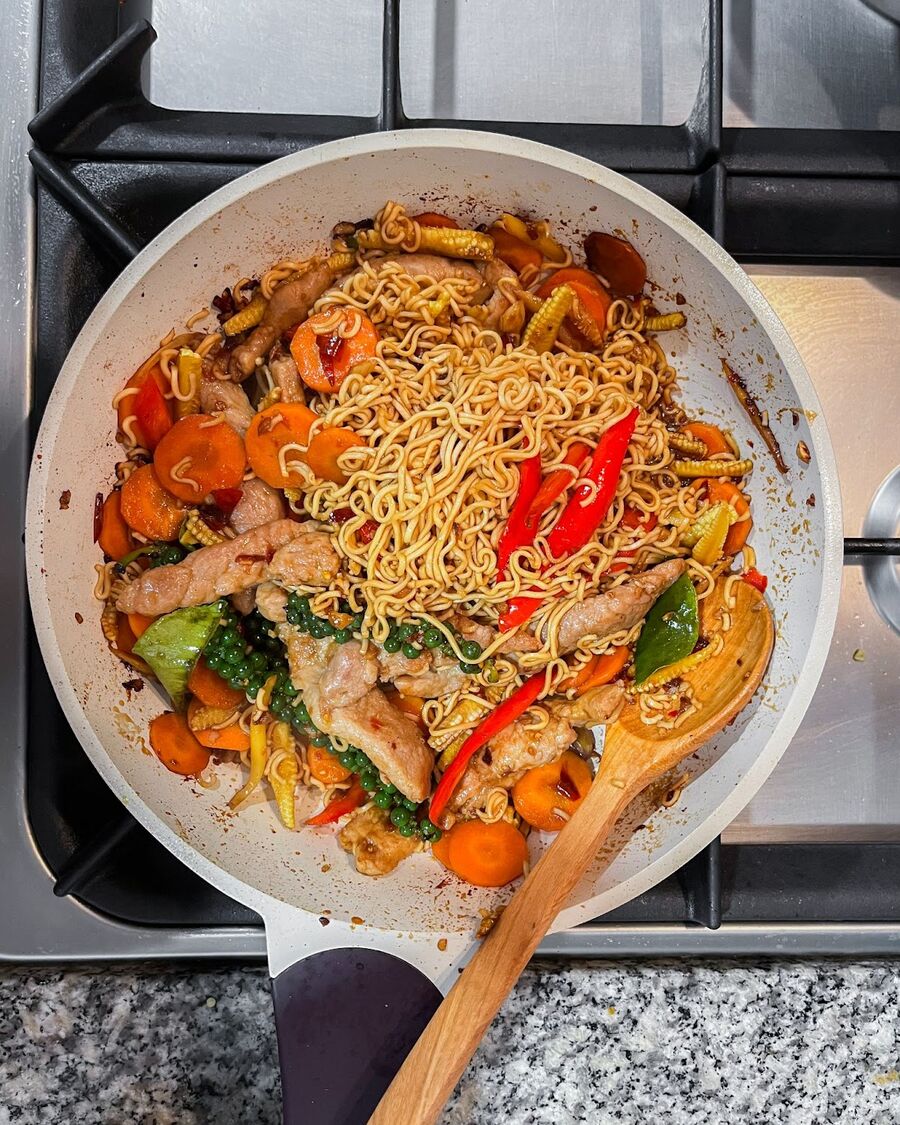 Keep stirring, then add Thai holy basil leaves and stir for another minute to evenly distribute the leaves.