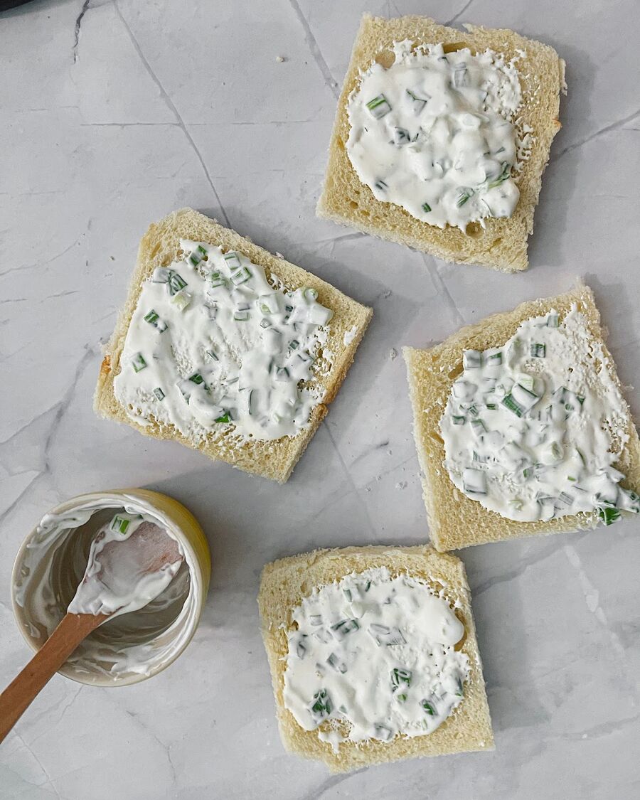 Trim the bread of its crusts and slather the cream cheese on each slice for a decadent taste experience.