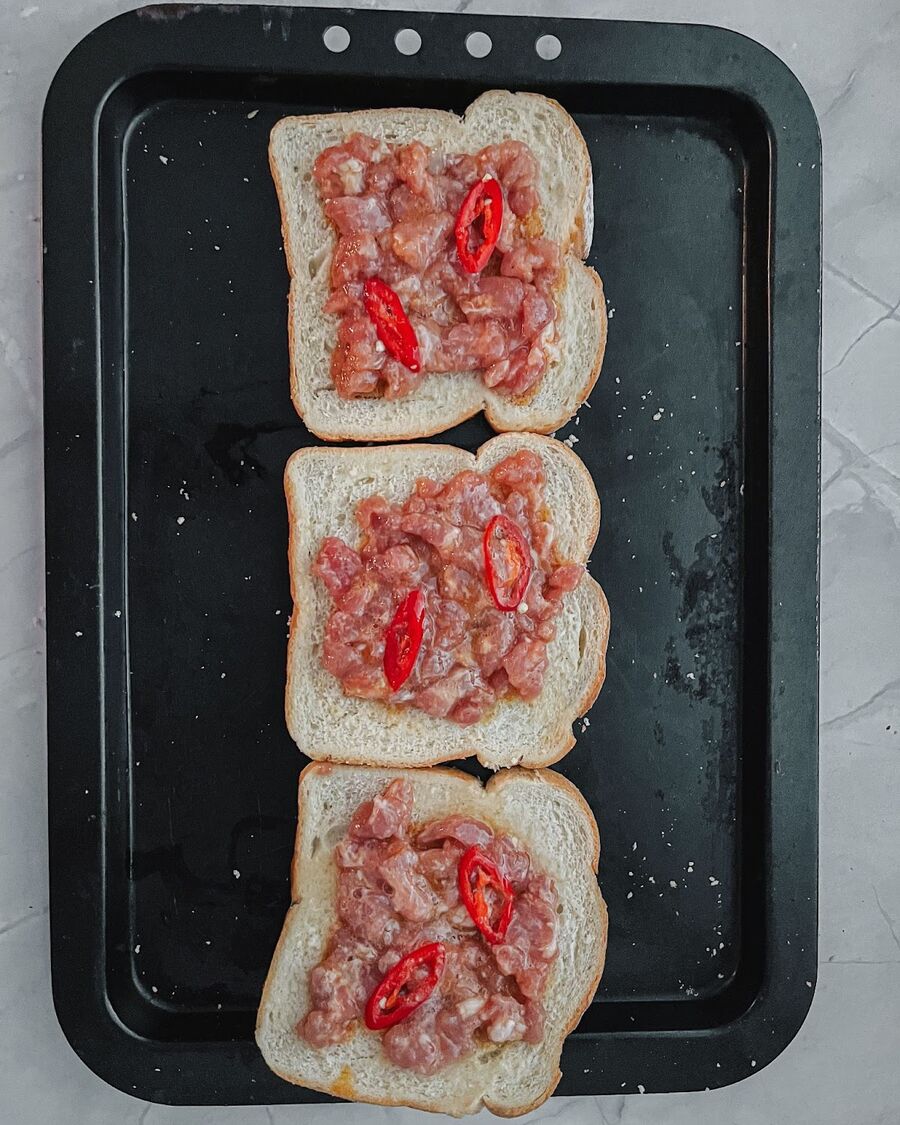 Spread the pork mixture evenly over the bread. Ensure that the pork mixture is not too thick.