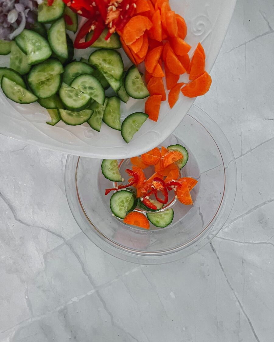Place the sliced vegetables in the cooled vinegar mixture and let them sit for approximately 10 minutes to absorb the flavors.