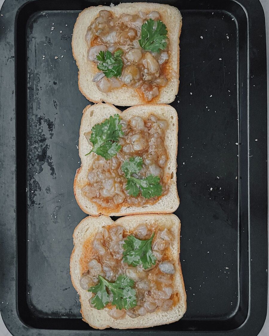 Spread the shrimp mixture evenly over the bread, being careful not to make it too thick.