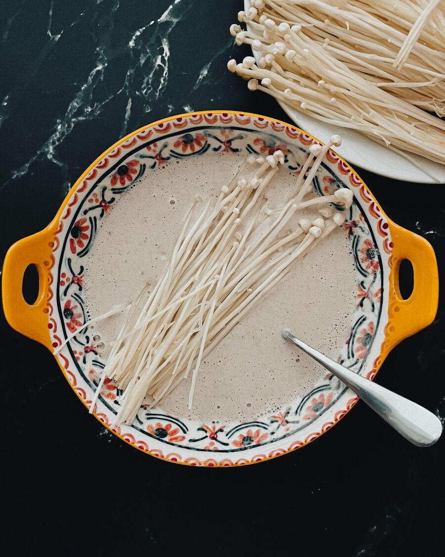 Dip the Enoki mushroom into the batter and coat them well.