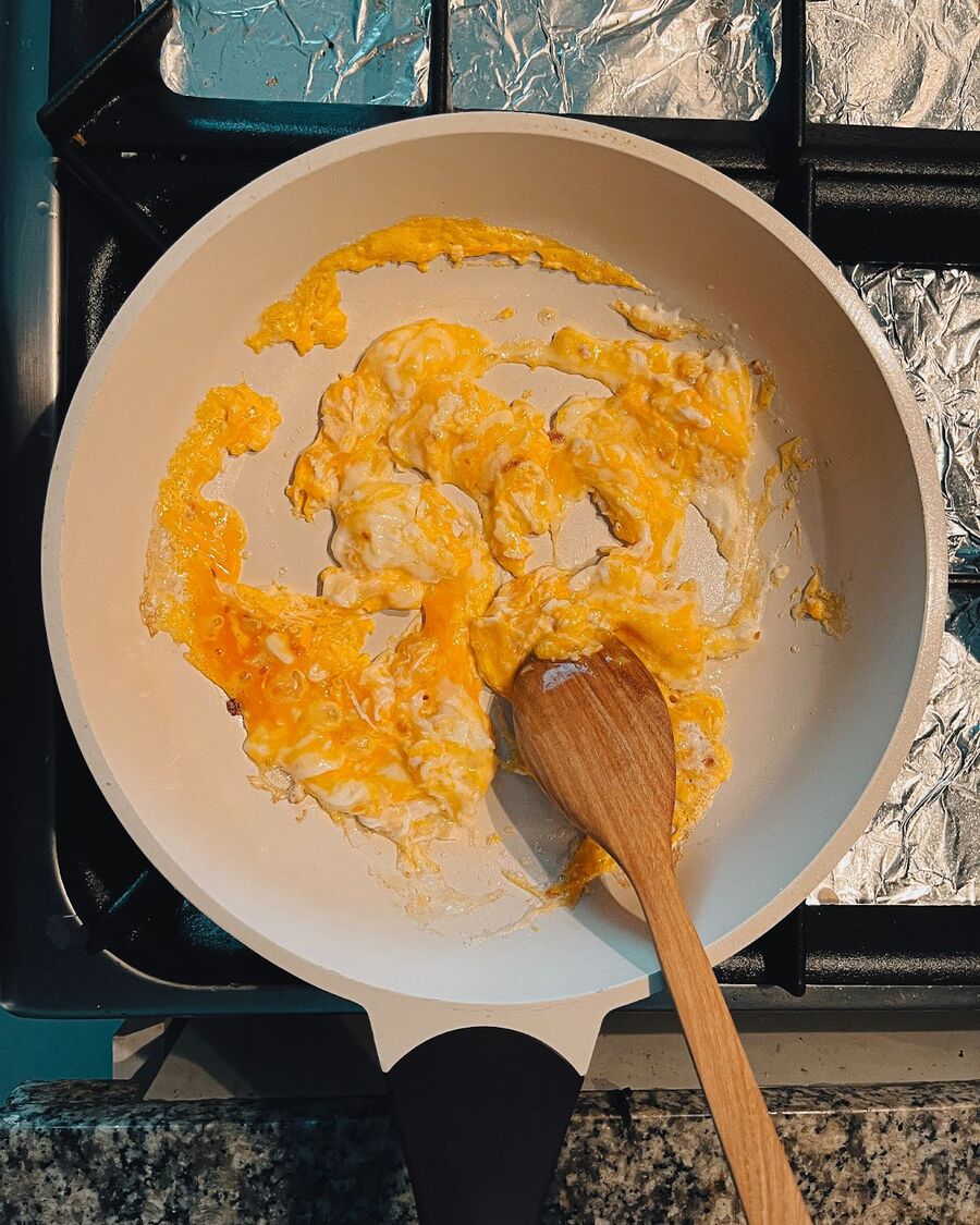 Pour the beaten eggs into the pan and scramble them.