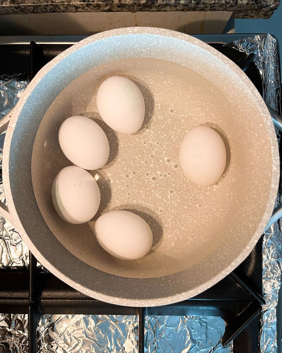 Boil the eggs for 8 minutes, then peel them and pat them dry with a kitchen paper towel. It is important to ensure that your boiled eggs are dry before frying them.
