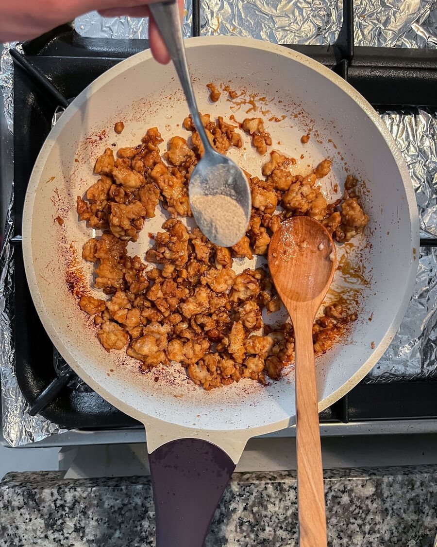 Stir and continue cooking until the chicken is fully cooked. Then, add the pepper powder and stir well to incorporate.