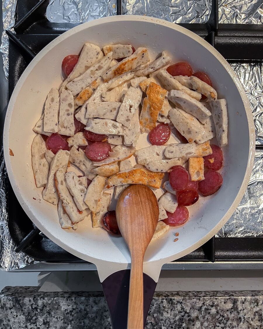 Using the same pan and remaining cooking oil from the garlic, add Chinese sausage and Vietnamese pork roll. Stir for a few minutes until they are fully cooked.