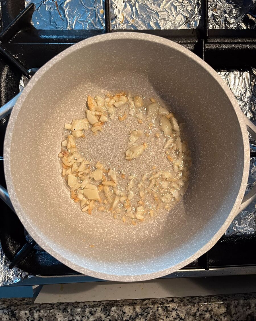 Heat a pan with cooking oil over medium-high heat. Add minced garlic to the oil and stir constantly until it turns yellow and becomes fragrant..