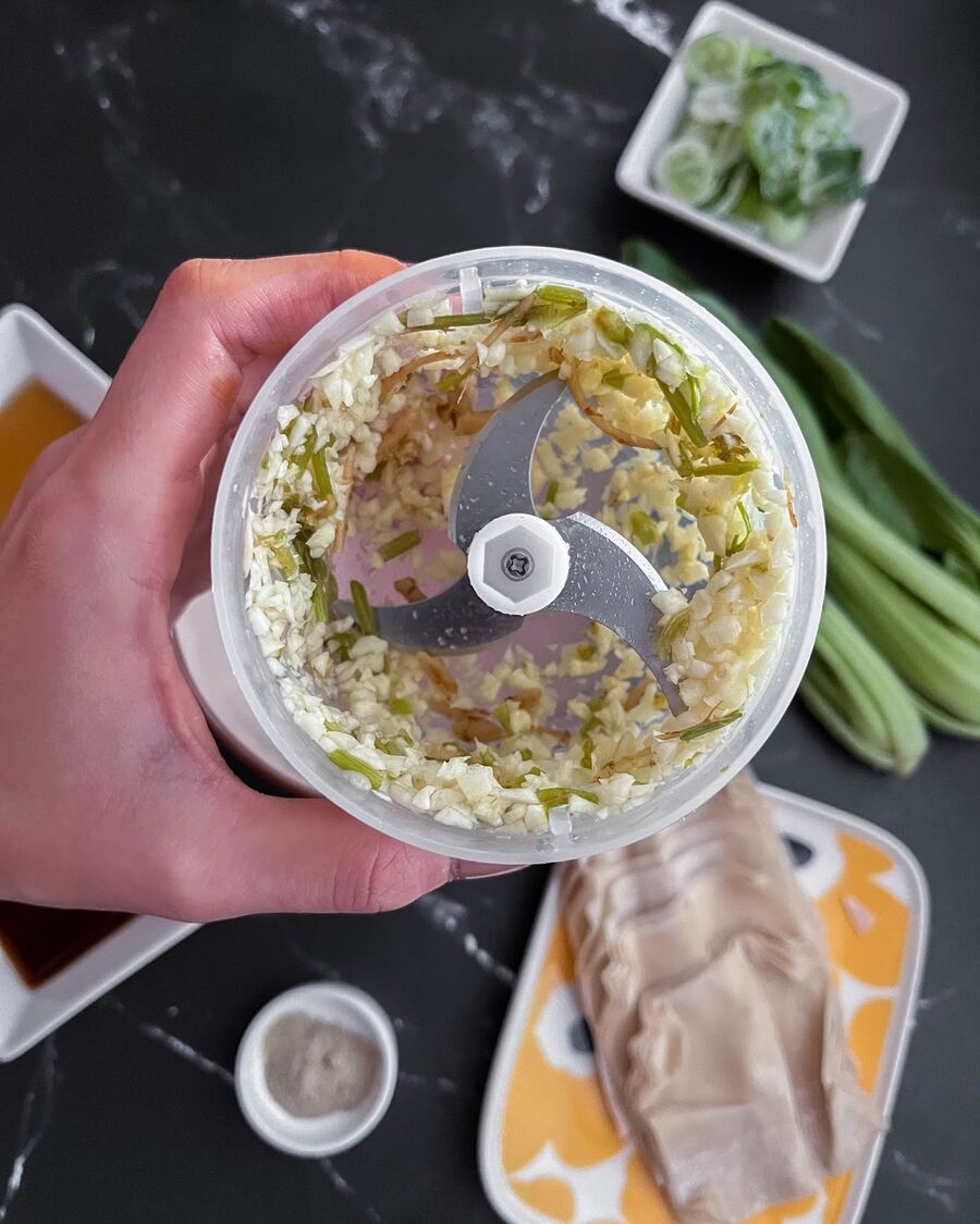 Using a food processor, combine garlic cloves and cilantro roots until well mixed.