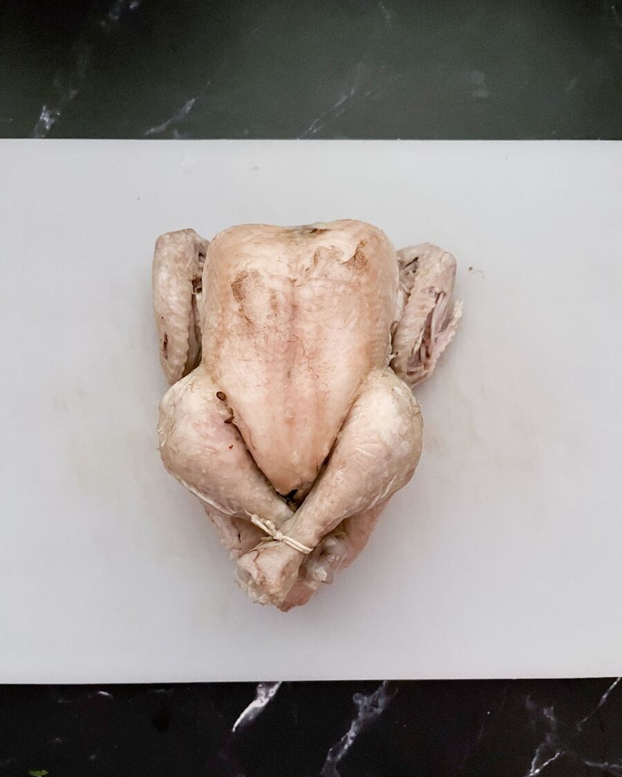 Let the broth boil for 40 minutes, then taste the soup to check the seasoning. If it's too bland, add more salt to enhance the flavor. Remove the cooked chicken from the soup and allow it to cool down.
