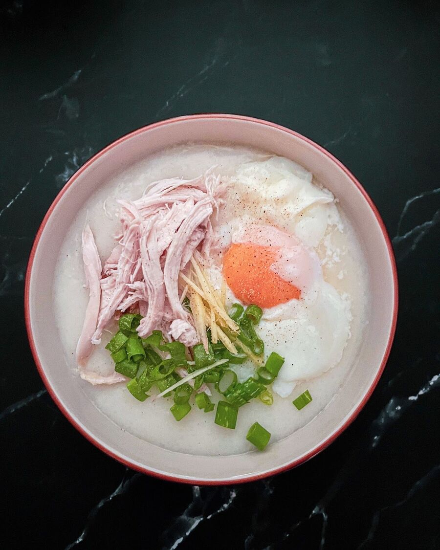 Once the rice porridge is ready, assemble your bowl by topping it with shredded chicken, soft-boiled egg, green onion, and ginger. Add soy sauce and ground pepper according to your taste preferences. Enjoy your delicious bowl of rice porridge!