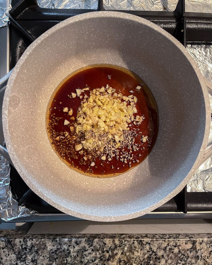 In a non-stick pot, combine the oyster sauce, soy sauce, ground pepper, sesame oil, and the blended ginger-garlic mixture from the food processor. Cook the sauce over medium-low heat.