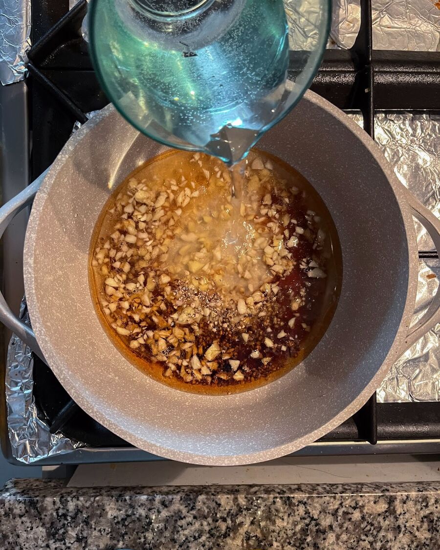Pour 1 cup of water into the pot and mix it well with the sauce for approximately 1 minute until the aroma of the herbs fills the air. Drain the soaked glass noodles and replace the water with the mixture sauce. Allow the glass noodles to soak in the sauce for about 5 minutes, allowing them to absorb the flavors.
