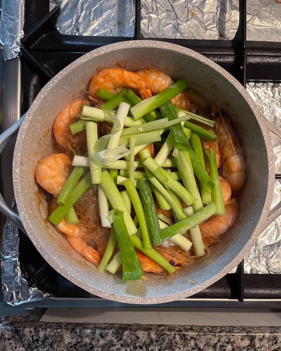 Turn off the heat and add some spring onions (green onions) to the dish.
