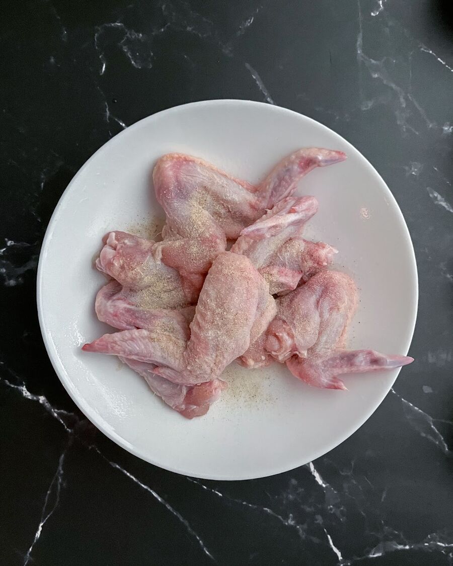 Marinate the wings with salt and pepper, rubbing them thoroughly.