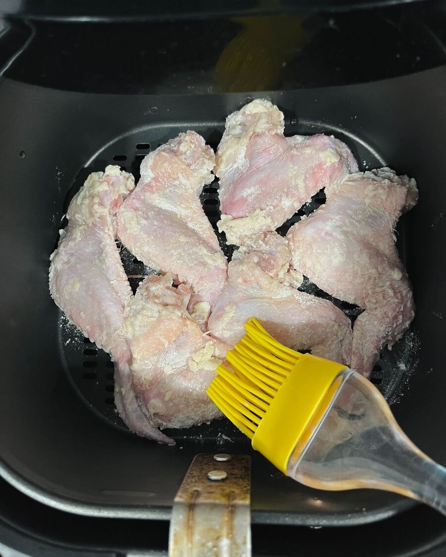 Set the Air Fryer to approximately 180°C. Place the wings in a single layer in the air fryer and spray the oil over them. Cook for about 10 minutes before flipping. If you don't have spray, you can use a brush to coat the cooking oil evenly over the wings.