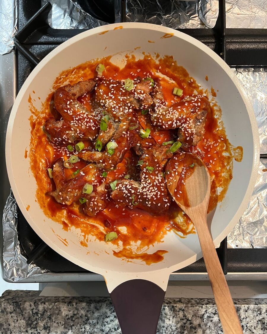 Garnish the wings with chopped spring onions and a sprinkle of sesame seeds.