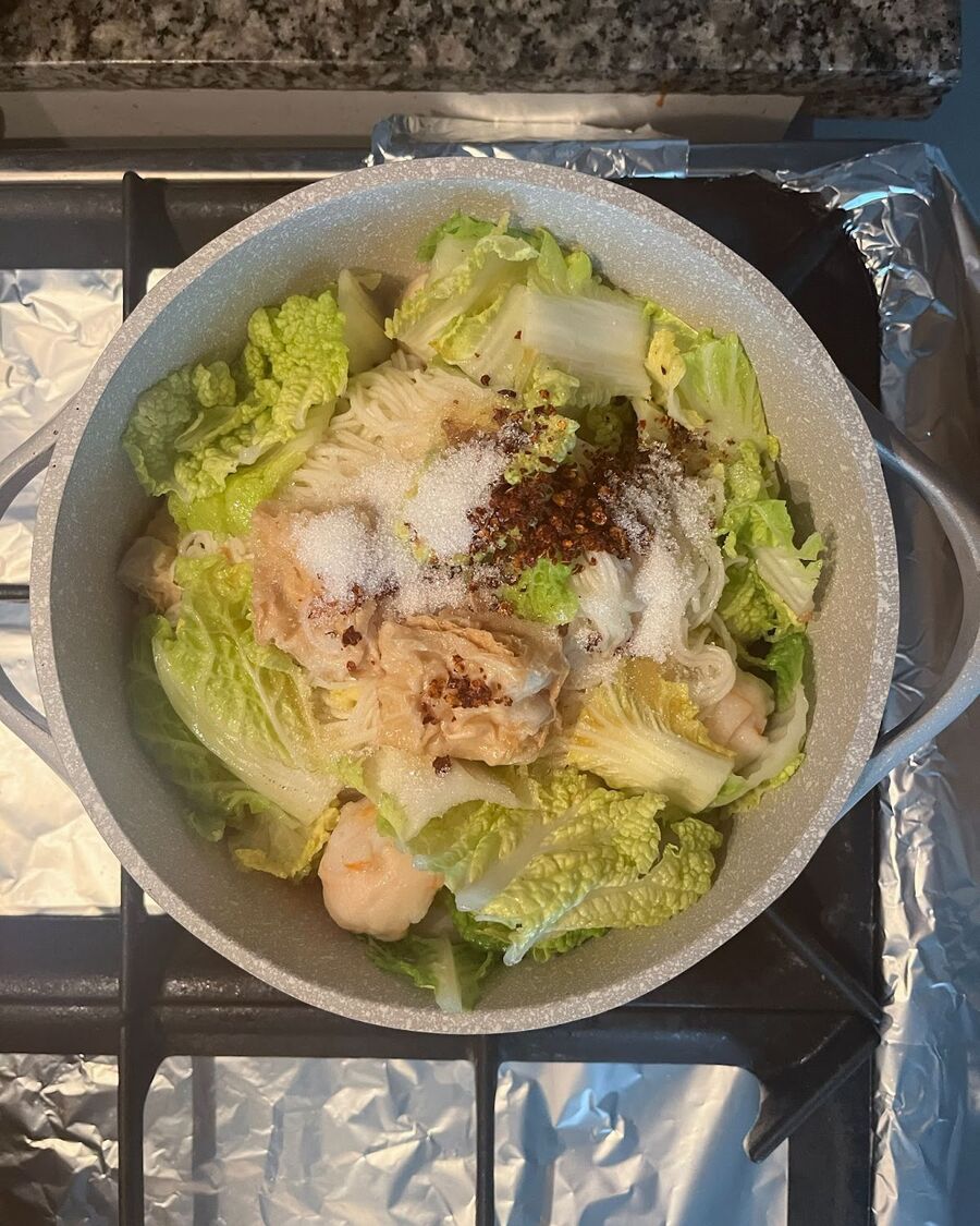 In the same pot with boiling water, blanch the vegetables for about 30 seconds or until they become soft. Remove all the boiling water. Add the cooked noodles, crab balls, fish balls, and vegetables to the pot, and mix them well with fish sauce, sugar, and chili flakes.