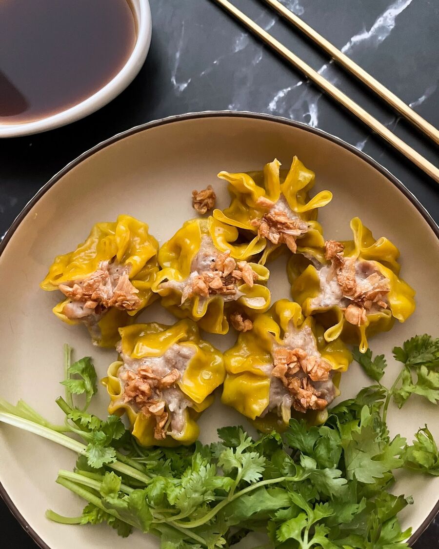 Create the sour soy dipping sauce by combining soy sauce, vinegar, and sugar, or consider purchasing it from an Asian supermarket. Sprinkle the steamed dumplings with fried garlic. Serve and enjoy!