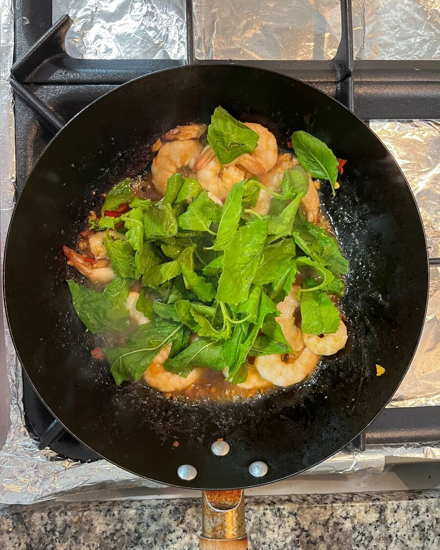 Add the Thai holy basil leaves to the mixture and turn off the heat. Give it one final stir to incorporate the basil leaves.