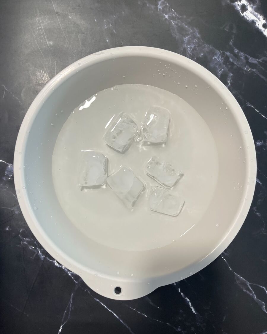 While you wait for the Kailan to cook, prepare a large bowl with 6-10 ice cubes and 1 cup of water. This trick will help maintain the fresh, vibrant green and crisp texture of the cooked Kailan.