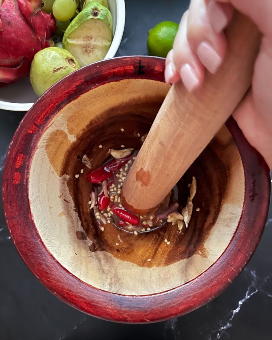 Use the pestle to thoroughly combine the chili, garlic, fish sauce, and palm sugar until the palm sugar is completely melted.